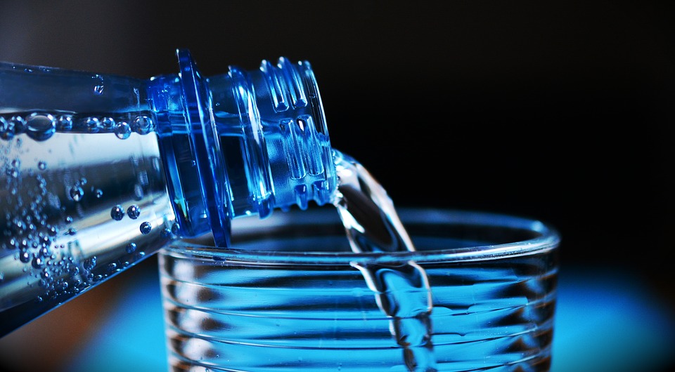 Poring a glass of water from a bottle