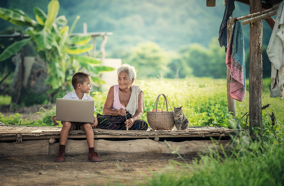 Young child showing his grandma what's on his laptop - online influencer